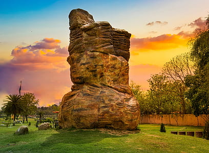 gray rock formation on grass field thumbnail