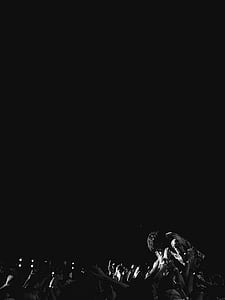 grayscale photo of person in front of crowd people thumbnail