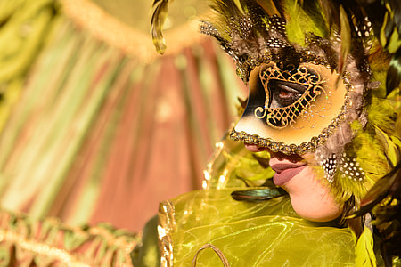 selective focus photography of person wearing yellow and black masquerade mask thumbnail