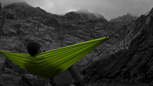 person sitting on green hammock near mountain thumbnail