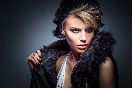 woman in white top and black fur-trimmed vest thumbnail