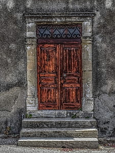 brown wooden door of gray concrete building thumbnail