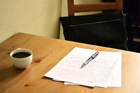gray pen on top of white papers and ceramic coffee on top of table thumbnail