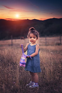 girl wearing blue chambray spaghetti strap dress holding purple striped bag during sunset thumbnail