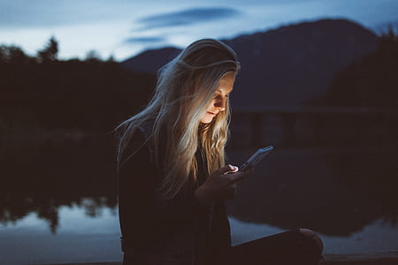 woman in black jacket holding white smartphone thumbnail