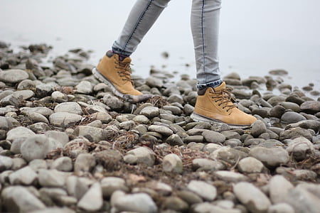 person walking on stony shore thumbnail