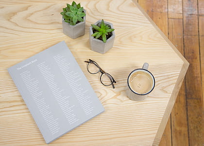 white ceramic mug beside eyeglasses on table thumbnail