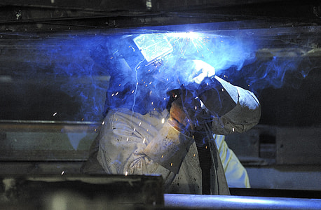 person wearing white overalls welding iron thumbnail