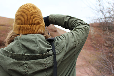 person wearing green jacket standing near tree at daytime thumbnail