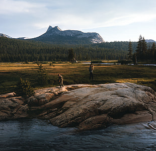 person standing on rock near body of water thumbnail