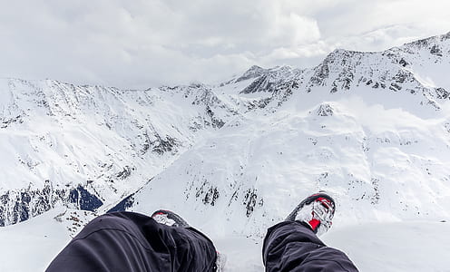 man sitting on snow-capped mountain thumbnail