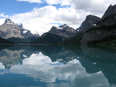 body of water near mountain during daytime thumbnail