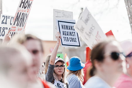 selective focus photography of woman protesting raising signboard thumbnail