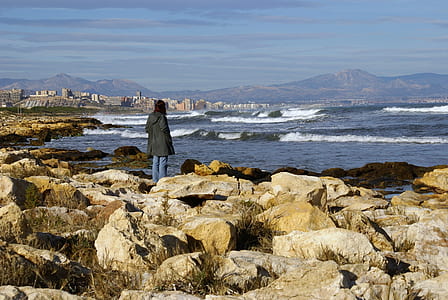 woman standing beside beach during daytime thumbnail