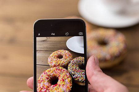 Donuts being captured with the camera of an iPhone mobile smartphone thumbnail