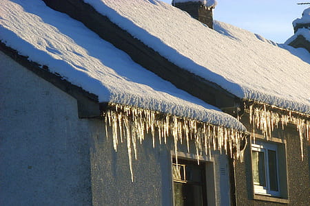 Icicles overhanging from a snow-covered roof in Scotland thumbnail