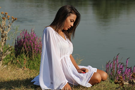 woman wearing white dress sitting on grass thumbnail