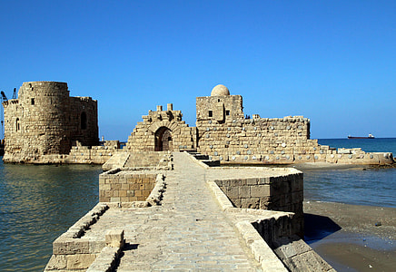 castle ruin surrounded by body of water thumbnail
