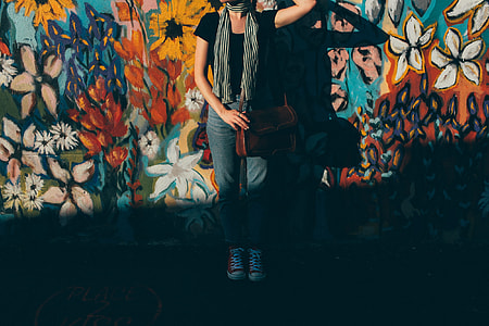 woman standing against wall with floral painting thumbnail