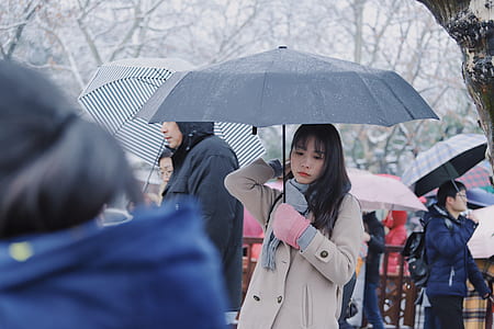 woman wears gray coat holds umbrella thumbnail
