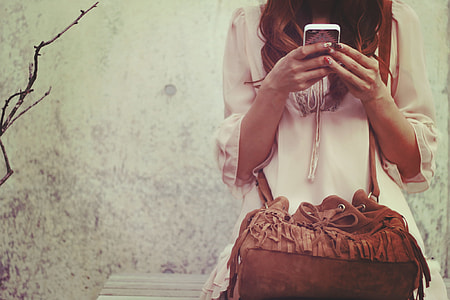 woman holding smartphone during daytime thumbnail