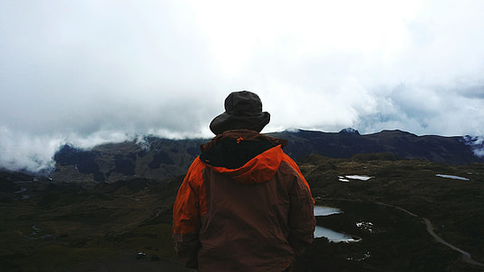 man standing on the hill looking at the mountain thumbnail