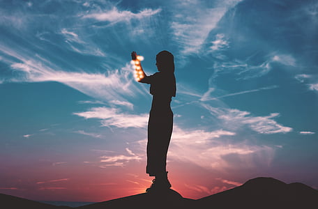 silhouette of person standing on hill thumbnail