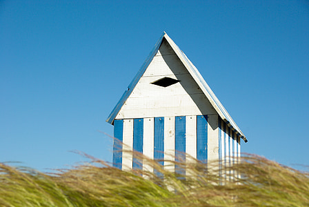 white and blue wooden house under clear blue skies thumbnail