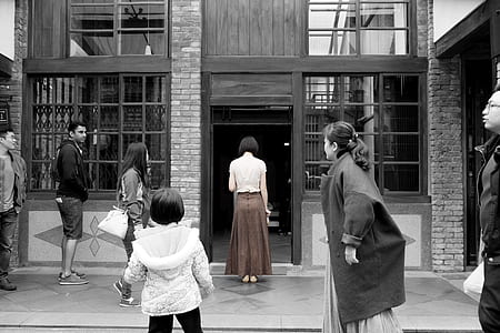 grayscale photography of people in front of concrete structure thumbnail