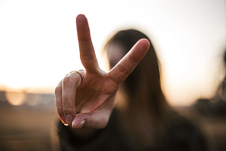 selective focus photography of woman's finger peace sign thumbnail