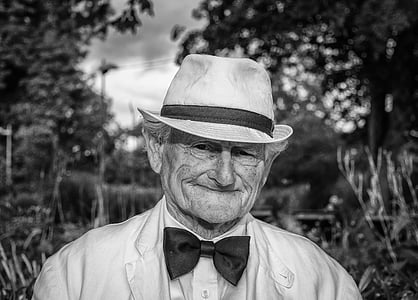grayscale photo of man wearing formal suit and bucket hat thumbnail