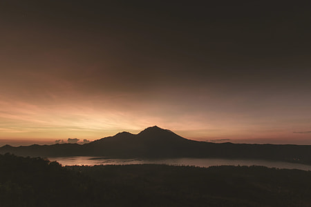 aerial photo of mountain near body of water in sunset thumbnail