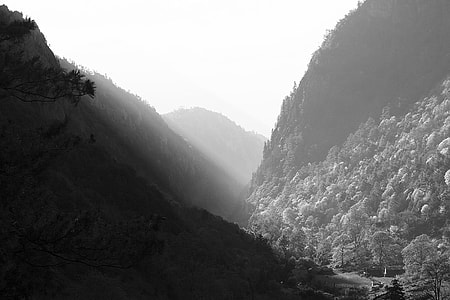 grayscale photography of mountains under sunny sky thumbnail