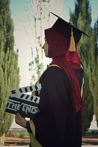 Woman Wearing Academic Dress While Holding Clipperboard thumbnail
