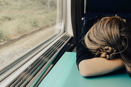 woman leaning on teal table inside vehicle near clear glass window thumbnail