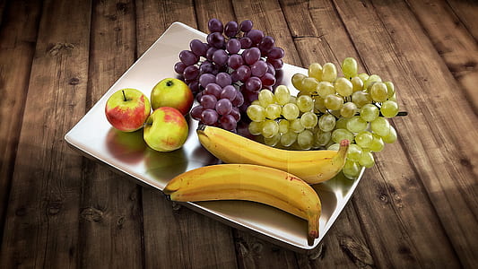 three green-and-red apples, two ride bananas and green-and-purple grapes on rectangular white ceramic plate thumbnail