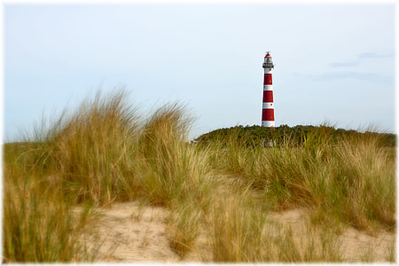 photography of white and red light house under cloudy sky during daytime thumbnail