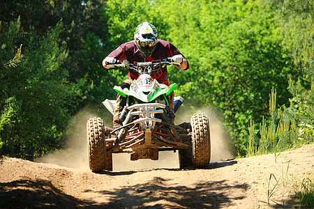 man riding green and white ATV thumbnail