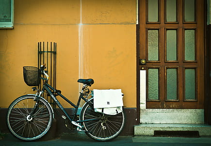 bicycle parked beside orange wall and door thumbnail