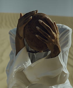 person holding his head while sitting on desert thumbnail