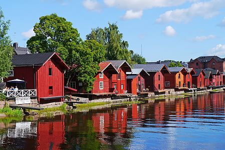 red and black wooden houses near water thumbnail