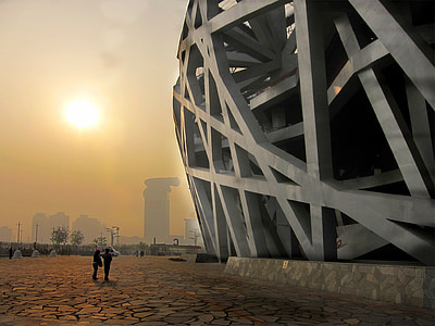 silhouette of two people standing near gray building structure thumbnail