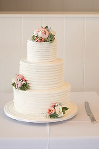 three tier floral cake near cake slicer thumbnail