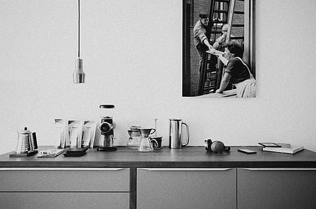 greyscale photo of sideboard under pendant lamp thumbnail