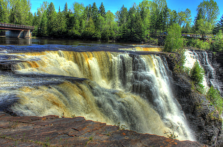 waterfalls with pine trees at daytime thumbnail