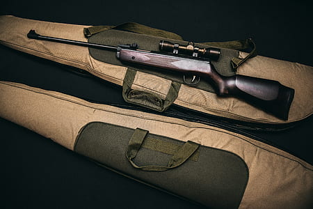 brown hunting rifle with scope on brown soft case thumbnail