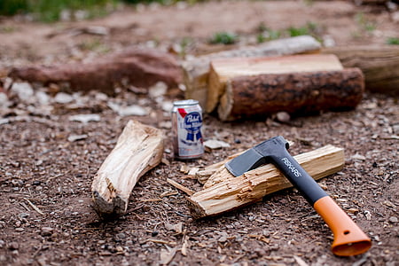 black and orange handle hatchet beside gray can thumbnail