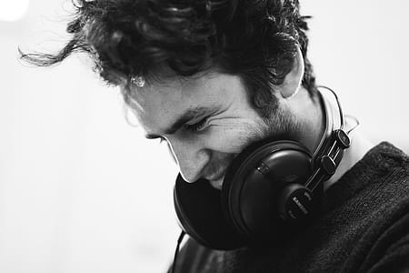 grayscale photography of man with headphones on his neck thumbnail
