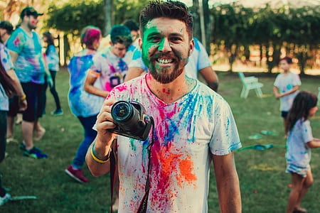 man holding DSLR camera with paints on face thumbnail