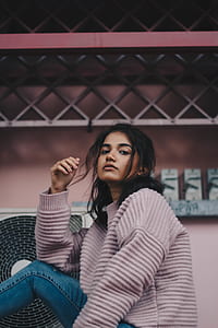 woman in gray sweater sitting near industrial fan thumbnail